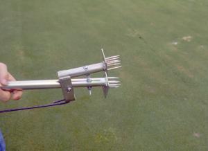 The Ball Mark Repair tool has stainless steel spikes that enter to soil and the trigger is squeezed together.  Next the ball mark is simply lifted up and repaired.